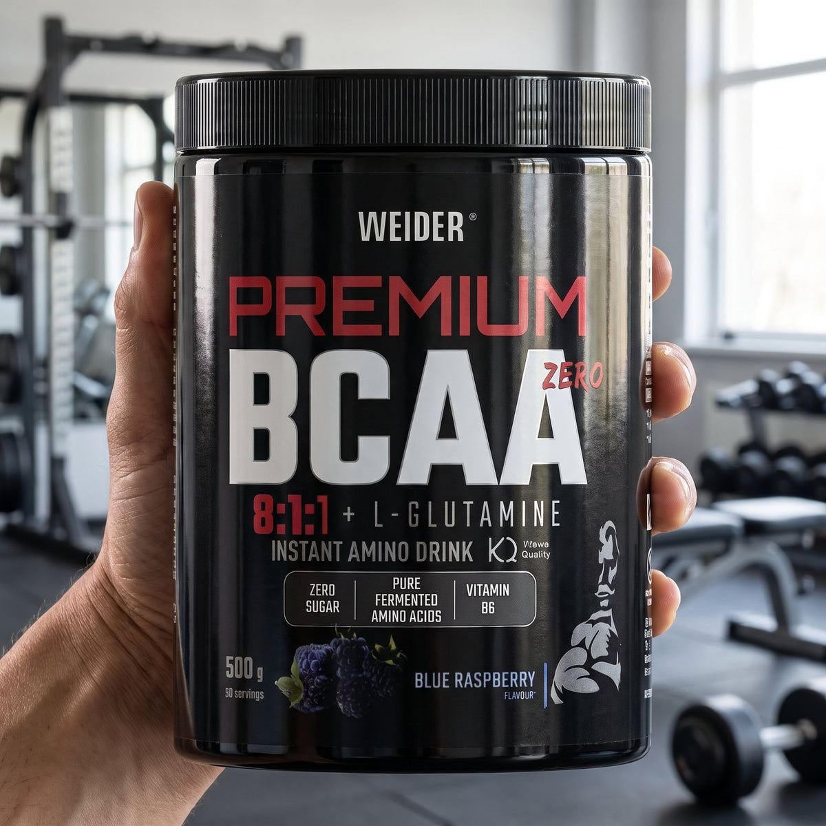 Weider BCAA and Glutamine, held in the hand in a gym