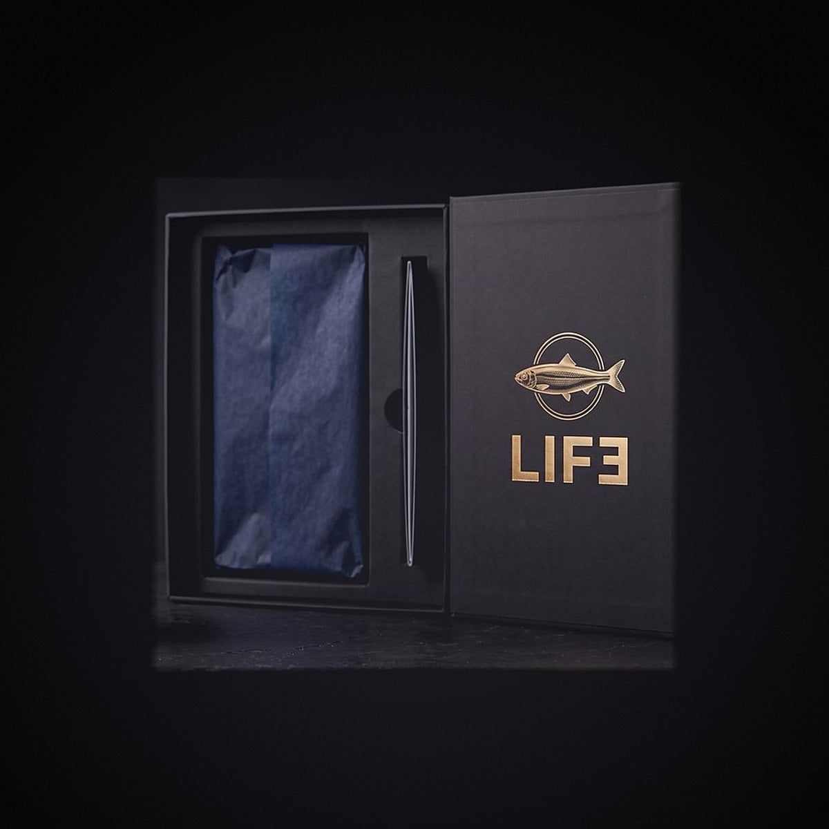 The LIF3 Omega-3 gift box open, navy tissue and fitted tray, herring crest and LIF3 wordmark in gold foil on the lid