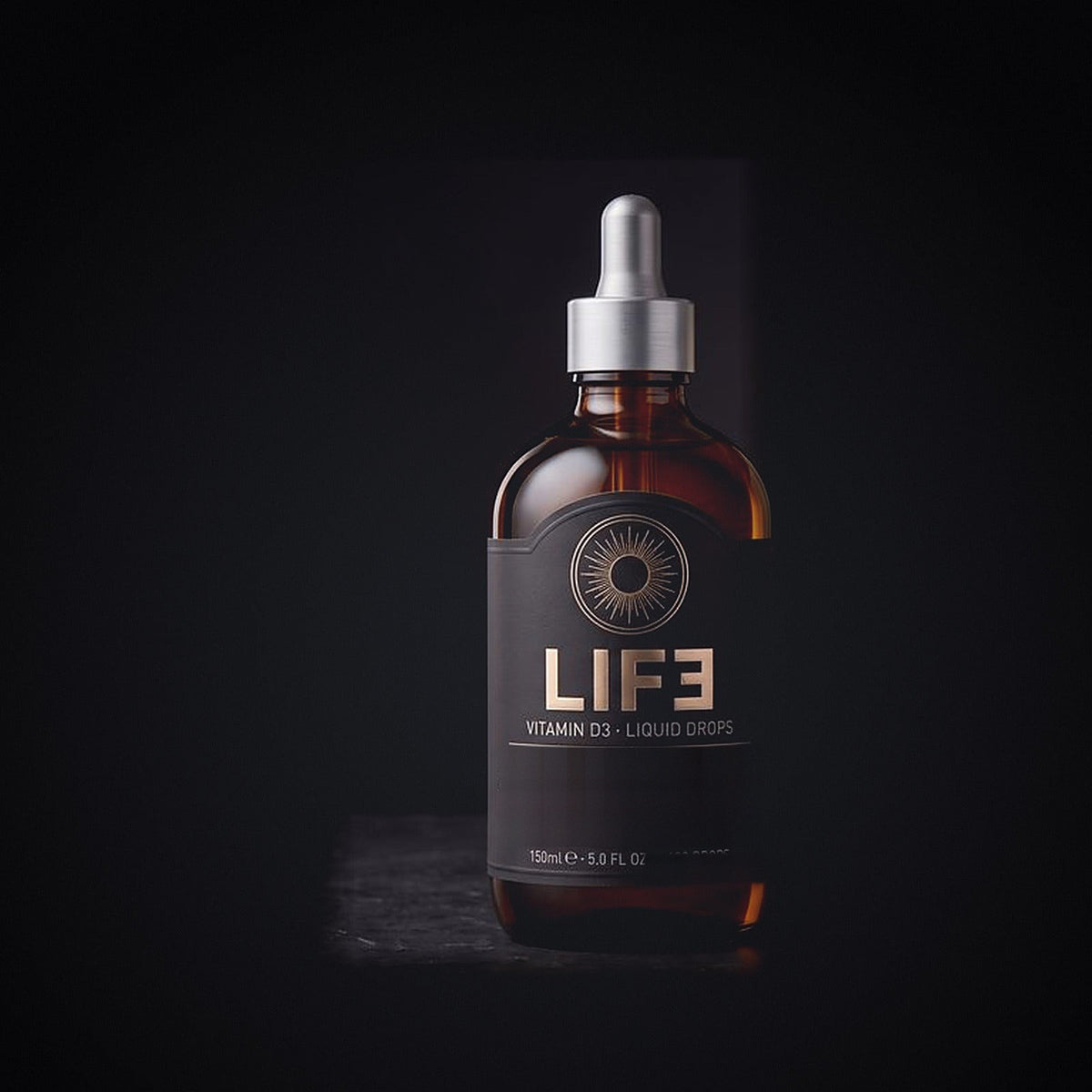 LIF3 Vitamin D3 liquid drops in a 150 ml amber dropper bottle, engraved sun crest in champagne gold on black