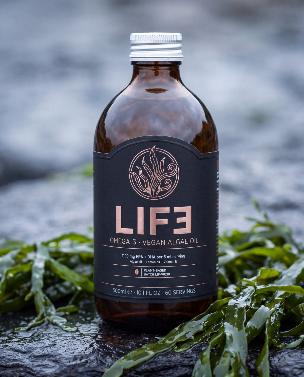 LIF3 Omega-3 vegan algae oil, 300 ml, on wet stone beside fresh seaweed