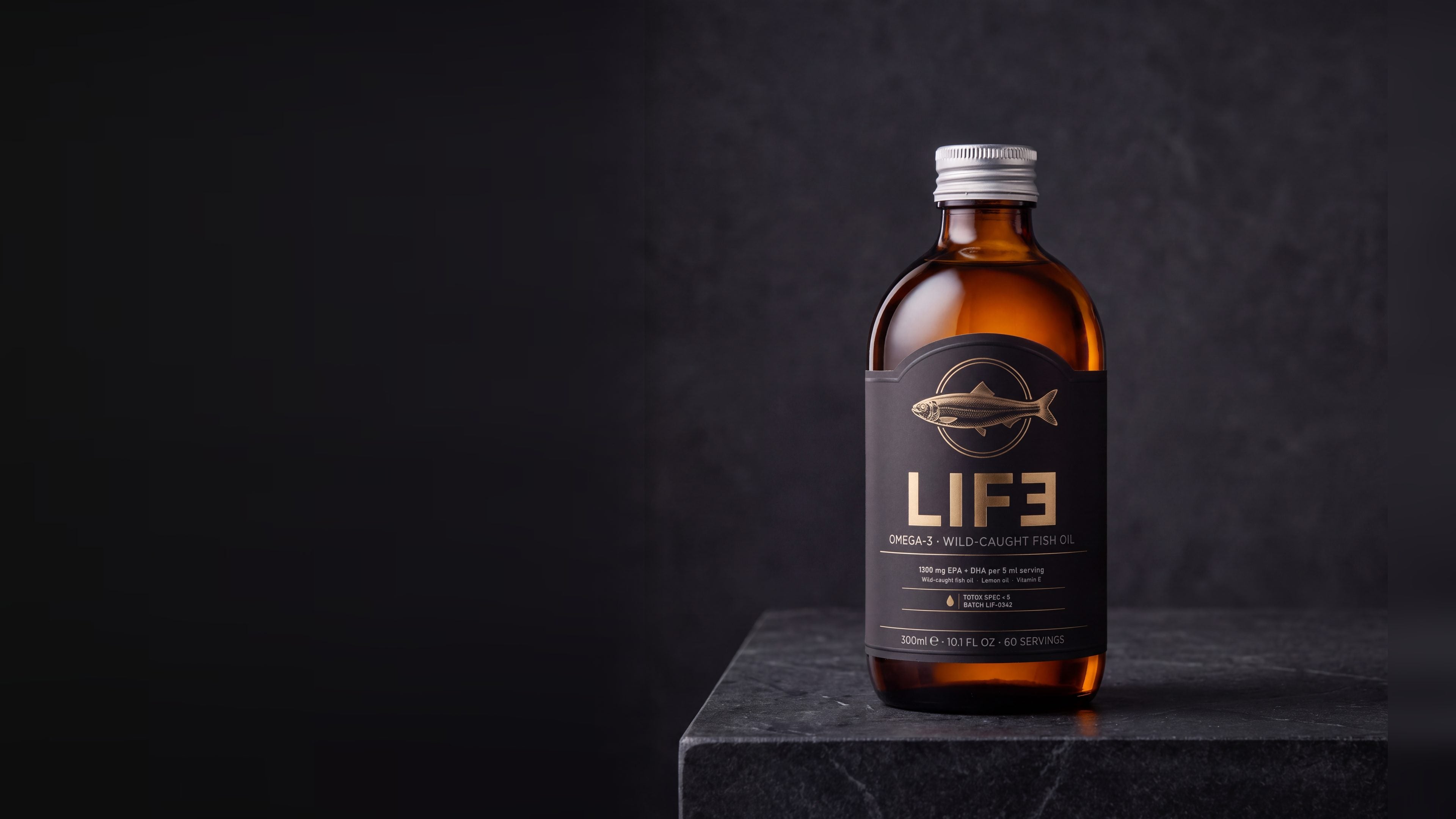 The LIF3 wild-caught fish oil bottle on dark stone